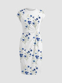 White maxi dress with blue floral print and twisted waist detail, front view.