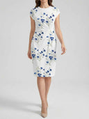 White knee-length dress with blue floral print and twisted waist detail, front view.