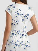White maxi dress with blue floral print, back view.