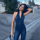 Dark wash denim halter jumpsuit with zipper, front view on a street.