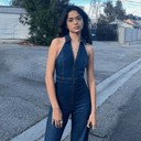 Denim halter jumpsuit with front zipper and collar, full-body view on street.