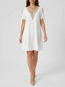 White V-neck knee-length dress with gold embroidered trim and tie sleeves, front view on a white background.