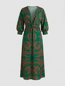 Green maxi dress with brown leaf pattern, V-neck, twisted front, and balloon sleeves, front view.