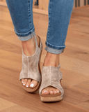Beige cork platform wedge sandals with open-toe cutout upper and stud trim, front angled view.
