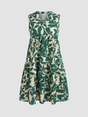 Cream and green leaf print tiered mini dress with V-neck, front view on white background.