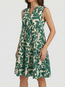Green and beige leaf print tiered mini dress with V-neck, angled front view.