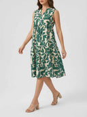 Green and beige leaf-print tiered mini dress, sleeveless, V-neck, angled view on a model.