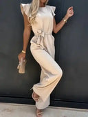 Beige ruffled sleeve jumpsuit with bow waist belt, angled front view against a dark wall.