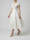 White A-line midi dress with lace bodice, short sleeves, and buttons, angled front view.
