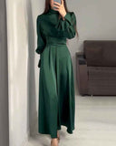 Emerald green maxi dress with high neck, ruffled cuffs, and ruched waist, front view.