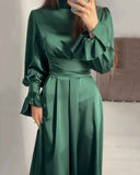 Emerald green maxi dress with ruffled cuffs and cinched waist, front view.