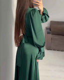 Green maxi dress with ruffled cuffs and tie-waist detail, back angled view.