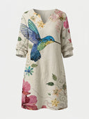 Beige mini dress with watercolor hummingbird and floral print, V-neck, and long sleeves, front view.