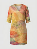 Beige mini dress with colorful skeletal leaf print, V-neck, and rolled sleeves, front view.