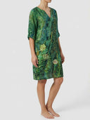 Green floral mini dress with V-neck and rolled sleeves, side view on white background.