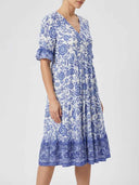 White and blue floral V-neck maxi dress with tiered skirt, side view.