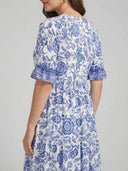 White and blue floral maxi dress with ruffled sleeves, back angled view.