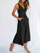 Black wide-leg overall with V-neck, twisted bust, and pockets, angled front view on white background.