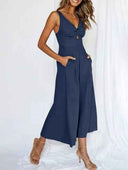 Navy blue wide-leg overall with knotted V-neck and pockets, front view.