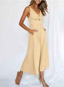 Tan wide-leg overall with V-neck, front knot detail, and pockets, angled view on white background.