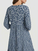 Blue mini dress with white floral print, long sleeves, and gathered waist, back view.