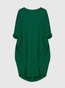 Green mini shirt dress with rolled sleeves and two front pockets, front view.