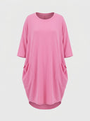 Pink mini shirt dress with round neck, short sleeves, and two large front pockets, front view.