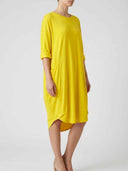 Yellow mini shirt dress with pockets, rolled sleeves, and high-low hem, angled side view.