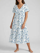 White V-neck mini dress with blue leaf print, short sleeves, and tiered skirt, front view.