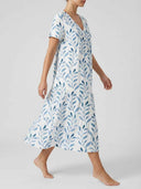 White V-neck mini dress with blue leaf print and tiered skirt, angled side view.