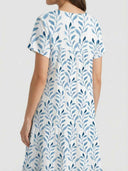 White mini dress with blue leaf print, back view on a light background.