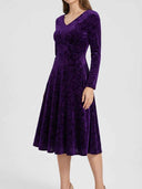 Purple velvet maxi dress with V-neck and long sleeves, angled front view on white background.