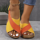 Yellow and orange colour-block flatform wedge sandals with cross-over straps and cork-look platform sole, angled front view.