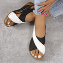 Black and white colour-block flatform wedge sandals with brown cork platform sole and white topstitching, worn on feet.
