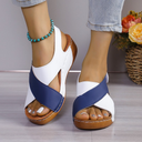 White and navy colour-block flatform wedge sandals with chunky wooden platform sole, worn on feet with gold ankle bracelet.