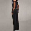 Black jumpsuit with sheer sleeves and studded cuffs, angled side view.