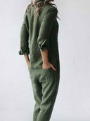 Olive green utility jumpsuit with rolled sleeves and pockets, angled side view.