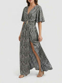 Gray and white patterned maxi dress with a gold buckle and high slit, front view.