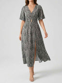 Gray patterned maxi dress with V-neck, short sleeves, gold buckle, and leg slit, front view.