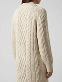 Cream cable knit mini dress, back angled view, showing textured knit patterns.
