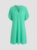 Mint green mini dress with ruched V-neck and short sleeves, front view on a white background.