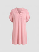 Pink mini dress with ruched V-neck and short sleeves, front view on a white background.