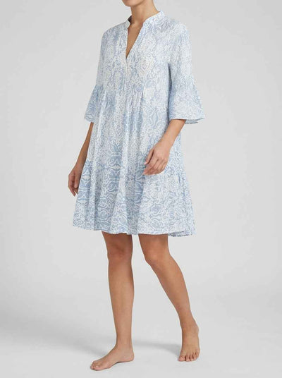 Viola boho mini dress in blue-and-white paisley print, three-quarter front view showing split notch neckline and wide 3/4 bell sleeves with tiered A-line skirt.