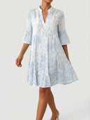 Blue-and-white boho mini dress with 3/4 bell sleeves and tiered A-line skirt, straight-on front view on white background.