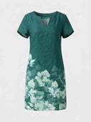 Viola teal mini shift dress with short sleeves, split V-neckline and tonal white border floral print on lower skirt, front view.