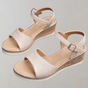 Cream beige espadrille wedge sandals with adjustable ankle strap and woven jute sole, angled front view showing buckle detail.