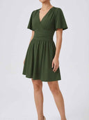 Olive green V-neck mini dress with ruched waist, front view on a white background.