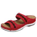 Red mesh platform slide sandals with black wave embroidered trim and cushioned rubber sole, angled side view.