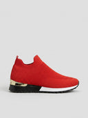Red slip-on knit trainer with gold heel accent, textured upper, and black and white non-slip rubber sole, side view.