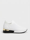 White slip-on knit trainer with gold heel accent, arch support footbed, and black non-slip sole, side view.
